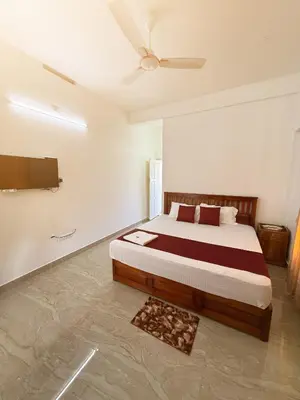 a bedroom with a bed and a ceiling fan at Paradise Premium Villa Munnar in Munnar