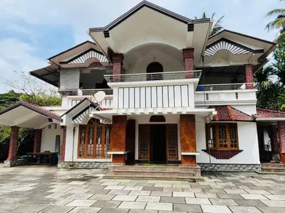 a large white house with a balcony on a patio at whisperingstrem's RIVER view homestay in Padinjarathara