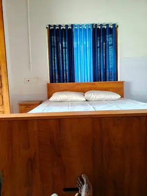a bed with two pillows at whisperingstrem's RIVER view homestay in Padinjarathara