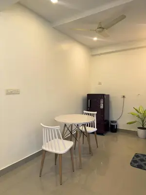 a table and two chairs in a room at Crest By Irishighes in Perintalmanna