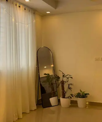 a mirror and potted plants in a room at Crest By Irishighes in Perintalmanna