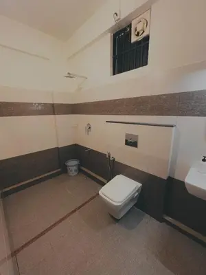 a bathroom with a toilet and a sink at Crest By Irishighes in Perintalmanna
