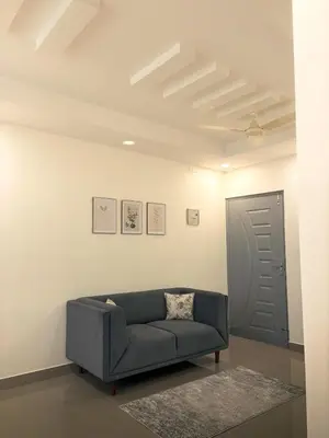 a living room with a blue couch and a door at Crest By Irishighes in Perintalmanna