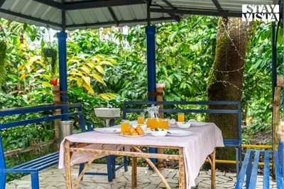 an outdoor table with a white table cloth and orange juice at StayVista at The River Mist with complimentary Breakfast & Bonfire in Wayanad