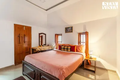 a bedroom with a large bed with orange sheets at StayVista at The River Mist with complimentary Breakfast & Bonfire in Wayanad
