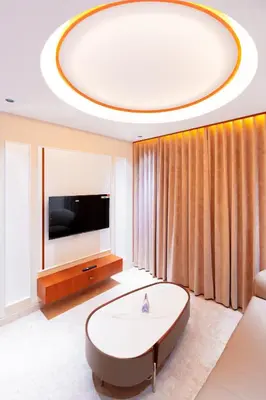 a living room with a large round table and a tv at celestia by thoppil in Kottakkal