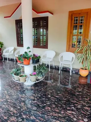 a group of chairs and potted plants in a room at Cozy Coffee Estate Homestay Coorg Madikeri in Madikeri