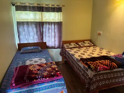 a bedroom with two beds and a window at Estate stay near Dubare elephant camp, friendly for remote workers in Siddapur