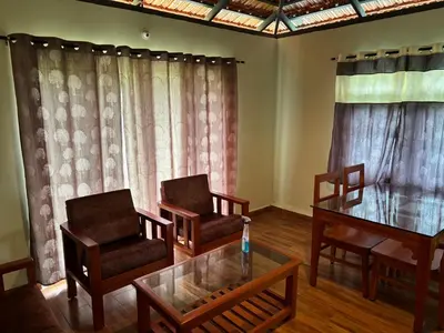 a living room with two chairs and a table at Estate stay near Dubare elephant camp, friendly for remote workers in Siddapur