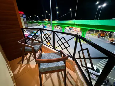 a pair of chairs sitting on a balcony at night at Shri Amman Residency in Dhārāpuram