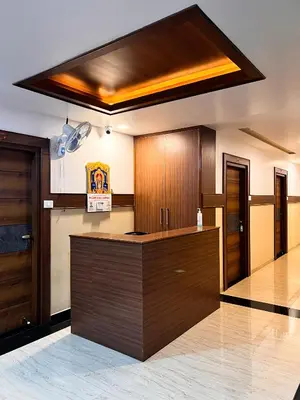 a kitchen with wooden cabinets and a counter top at Shri Amman Residency in Dhārāpuram