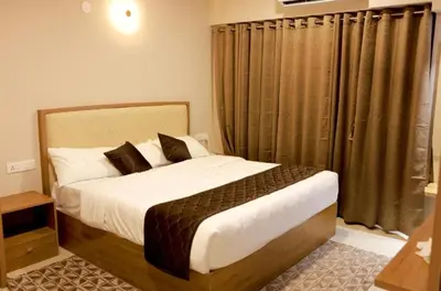 a bedroom with a large bed and a window at Lavender Airport suite in Nedumbassery