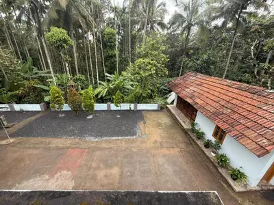 a house with a red roof and a yard at Resonanace Homestay Nature Stay in Wayanad in Pulpally