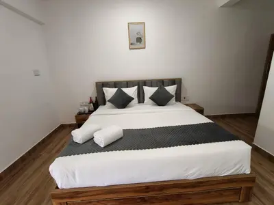 a bedroom with a large bed with two pillows at Nirvanica Retreat Wayanad in Padinjarathara