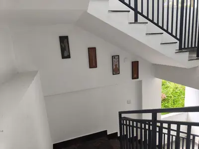 a staircase in a house with pictures on the wall at Nirvanica Retreat Wayanad in Padinjarathara