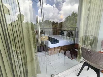 a glass balcony with a view of a pool at Nirvanica Retreat Wayanad in Padinjarathara
