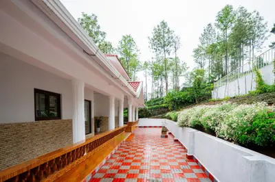 a corridor of a building with a red and white tile floor at SaffronStays Chamomile Hills in Kotagiri