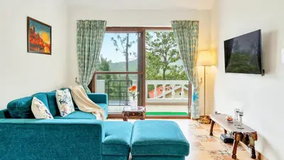 a living room with a blue couch and a window at SaffronStays Chamomile Hills in Kotagiri