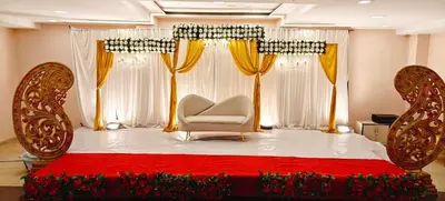 a room with a bed and a chair and curtains at RR Grand Inn in Coimbatore