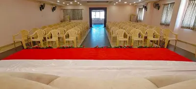 an empty room with chairs and a red carpet at RR Grand Inn in Coimbatore