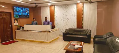 two men standing at a reception desk in a lobby at RR Grand Inn in Coimbatore