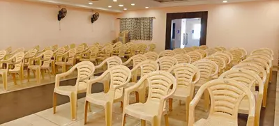 an empty room with rows of chairs in a classroom at RR Grand Inn in Coimbatore