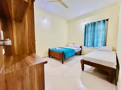 a room with two beds and a window at Rohi stays 2 bed room flats in Mysore