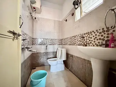 a bathroom with a toilet and a sink at Rohi stays 2 bed room flats in Mysore