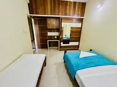 a small room with two beds and a mirror at Rohi stays 2 bed room flats in Mysore