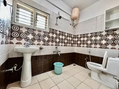 a bathroom with a sink and a toilet at Rohi stays 2 bed room flats in Mysore