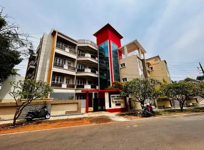 a large building with a large red building at Rohi stays 2 bed room flats in Mysore