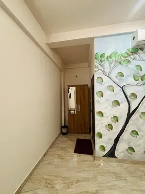 a hallway with a wall with a tree mural at Apple Tower Stays in Meppādi
