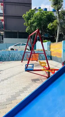 a playground with a red frame in a city at Apple Tower Stays in Meppādi