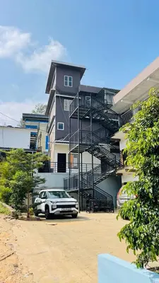 a house with a car parked in front of it at Apple Tower Stays in Meppādi