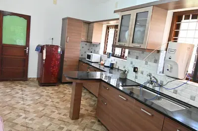 a kitchen with a sink and a refrigerator at Willy's Home Stay in Parūr