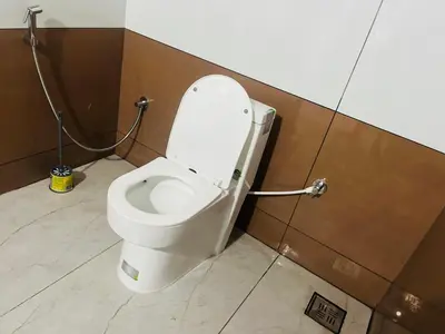 a bathroom with a toilet with the lid up at Edakkal Hearth in Ambalavayal