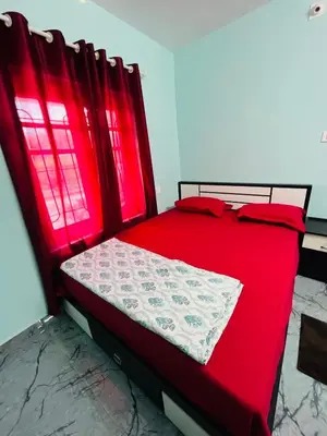a red bed with red sheets and red pillows at Edakkal Hearth in Ambalavayal