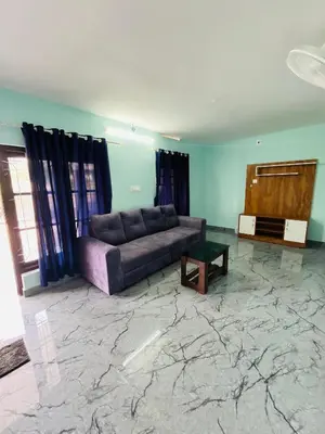 a living room with a couch and a table at Edakkal Hearth in Ambalavayal