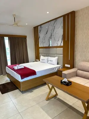a bedroom with a bed and a couch and a table at Rivera resort and wellness center in Kodanad