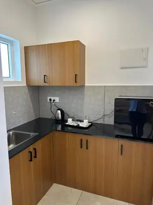 a kitchen with a sink and a microwave on a counter at Rivera resort and wellness center in Kodanad