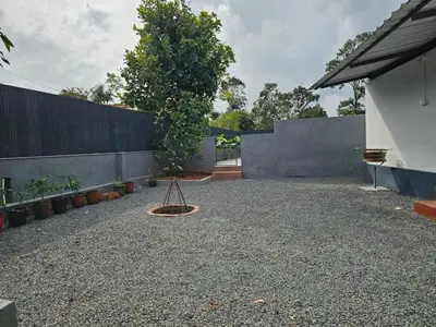 a yard with a fence and a tree and a swing at Mount Wave Holiday Pool Villa in Wayanad