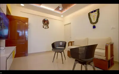 a living room with a chair and a couch at Padmalaya Homestay ! in Guruvāyūr