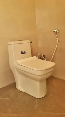 a toilet with a sticker on the back of it in a bathroom at Eden Garden Bandipur Tiger Reserve in Gundlupet