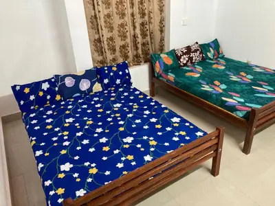 a bed and a couch in a room at nandanam villlas in Guruvāyūr