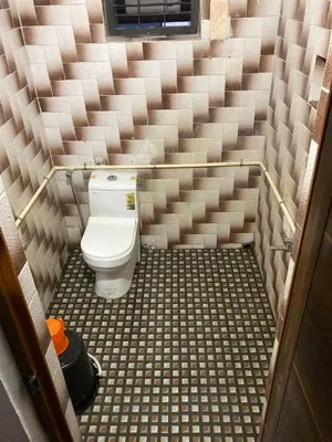 a small bathroom with a toilet in the middle at nandanam villlas in Guruvāyūr
