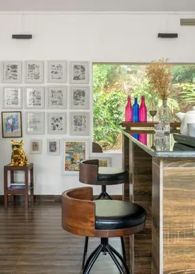 a kitchen with a counter and two stools in a room at Lolo's by Raho - Loft Stay in Coorg in Ammatti
