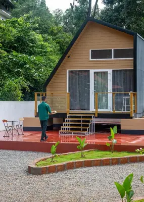 a man standing in front of a tiny house at Lolo's by Raho - Loft Stay in Coorg in Ammatti