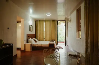a large bedroom with a bed and a window at Greenex farm Resort in Vythiri