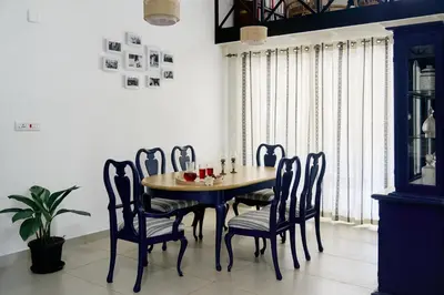 a dining room with a wooden table and chairs at Okka by Raho - A colonial style villa in Coorg in Siddapur