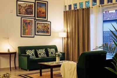 a living room with a green couch and a table at Okka by Raho - A colonial style villa in Coorg in Siddapur